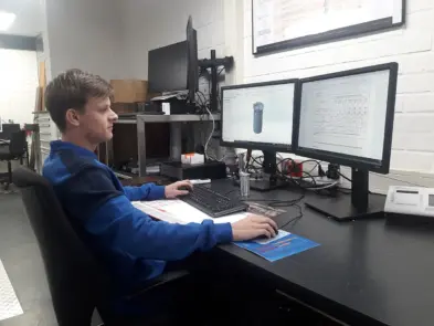 Ties (17 jaar) werkend aan een bureau op een afdeling bij Pillen Group.